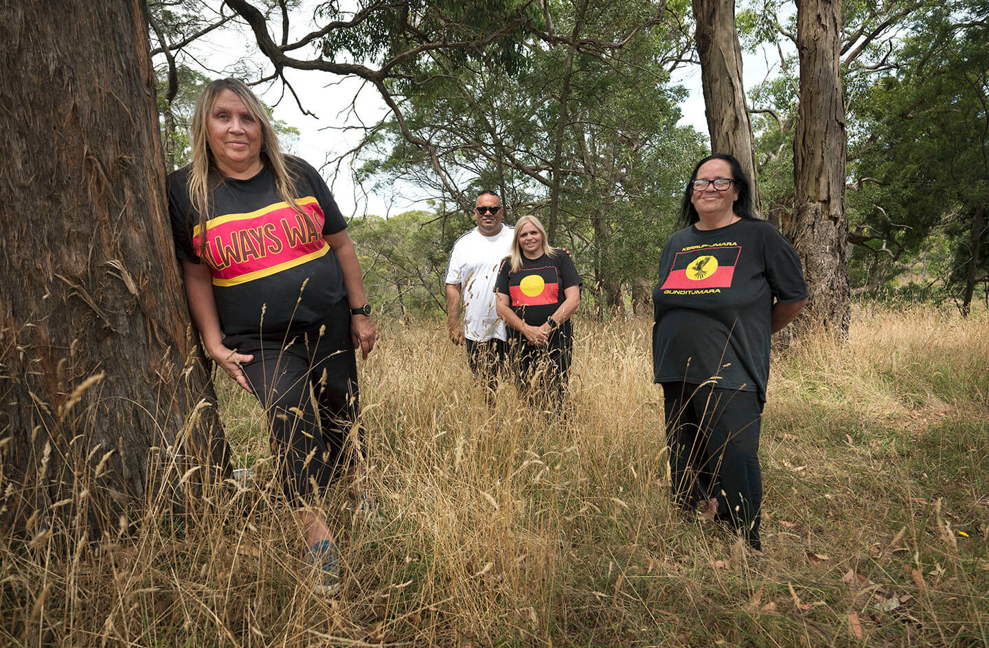 The Wright family standing out in high grassland next to gum trees.